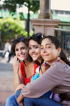 Side profile of three young women sitting together and smiling, Old San Juan, San Juan, Puerto Rico