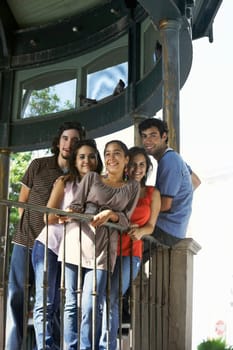 Portrait of two young men and three young women standing together and smiling