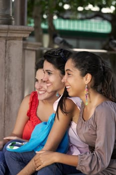 Three young women sitting together and smiling