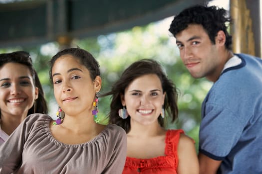 Portrait of a young man with three young women posing and smiling