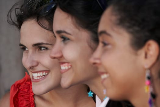 Side profile of three young women smiling