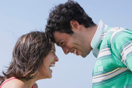 Side profile of a young couple looking at each other and smiling