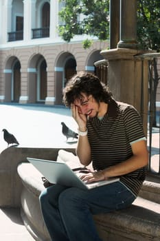 Young man using a laptop and laughing