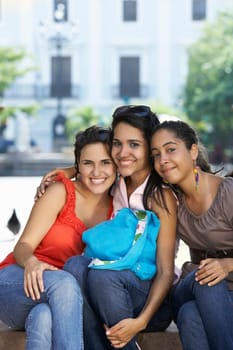Portrait of three young women sitting and smiling