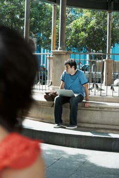 Young man sitting with a laptop