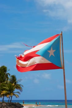 Puerto Rican flag fluttering on the beach, Luquillo Beach, Puerto Rico
