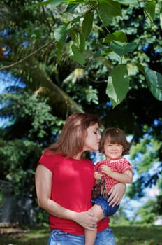 Young woman kissing her daughter
