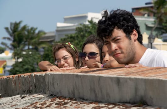 Side profile of a young man with three young women looking over a castle wall, Morro Castle, Old San Juan, San Juan, Puerto Rico