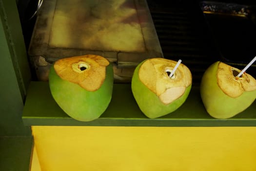 Drinking straws in green coconuts