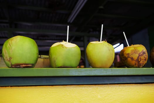 Drinking straws in green coconuts
