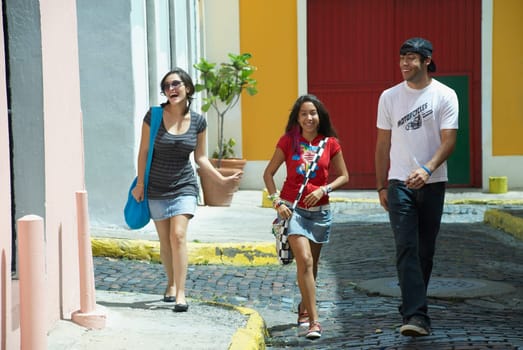 Young man walking with two young women on a cobblestone street, Old San Juan, San Juan, Puerto Rico