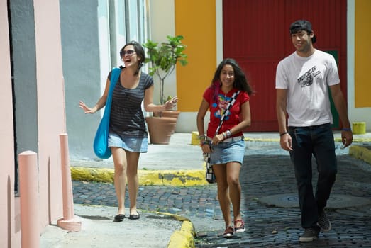 Young man walking with two young women on a cobblestone street, Old San Juan, San Juan, Puerto Rico