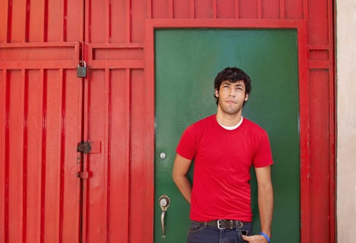 Young man standing in front of a closed door