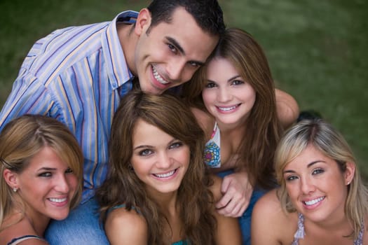 Portrait of four young women smiling with a young man