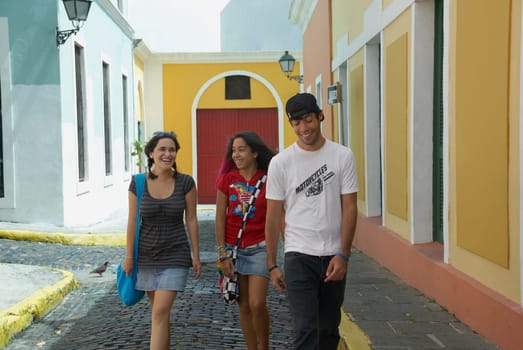 Young man walking with two young women on a cobblestone street, Old San Juan, San Juan, Puerto Rico