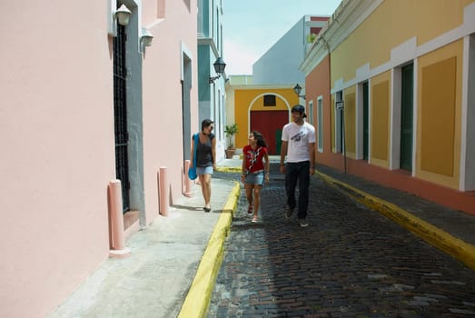 Young man walking with two young women on a cobblestone street, Old San Juan, San Juan, Puerto Rico