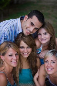 Portrait of four young women smiling with a young man