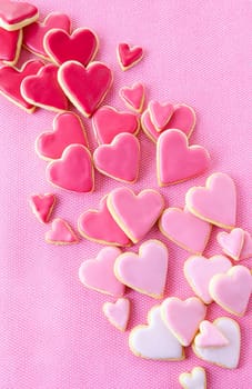 Little cookie hearts with pink icing on a pink background