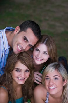 Portrait of three young women smiling with a young man