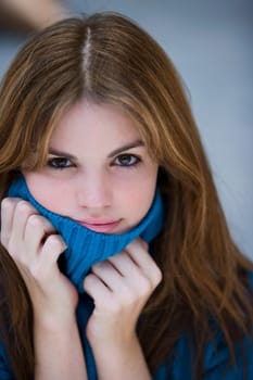 Portrait of a young woman hiding her face with her sweater