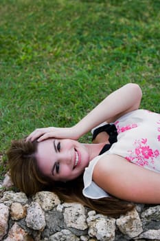 Portrait of a young woman lying on a ledge and smiling