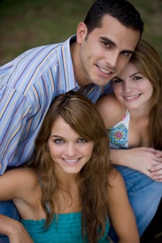 Portrait of a young man smiling with two young women