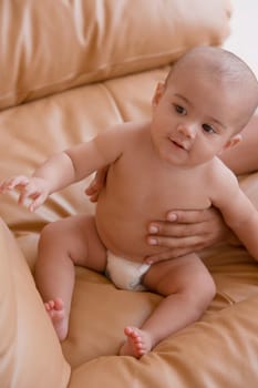 Close-up of a baby boy sitting on a couch