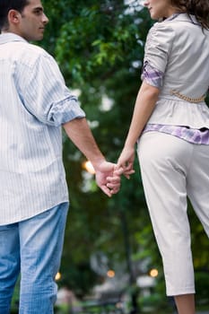 Rear view of a young couple holding hands of each other
