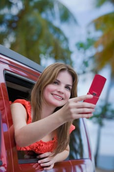 Young woman taking a picture with a mobile phone and looking away