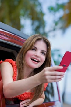 Young woman taking a picture with a mobile phone and laughing