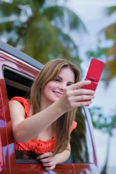 Young woman taking a picture with a mobile phone and smiling