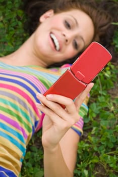 High angle view of a young woman holding a mobile phone and smiling