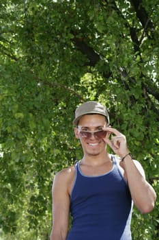 Portrait of a young man peeking over his sunglasses