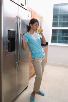Teenage girl drinking orange juice from a glass