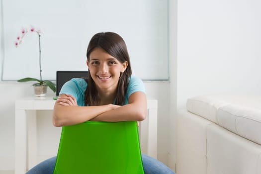 Teenage girl sitting on a chair and smiling