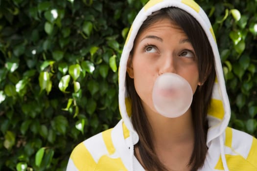 Teenage girl blowing a bubble gum
