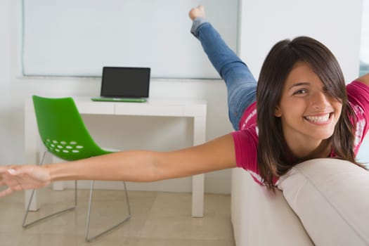 Teenage girl playing on a couch