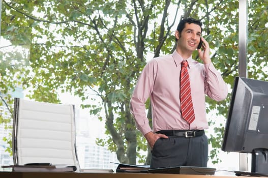 Businessman talking on a mobile phone in an office