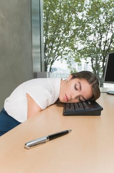 Businesswoman sleeping on a desk in an office