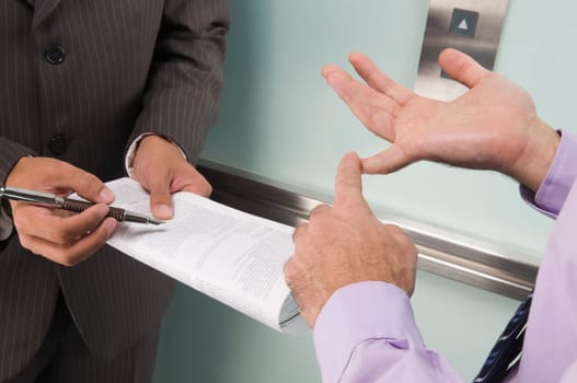 Businessmen discussing in an elevator