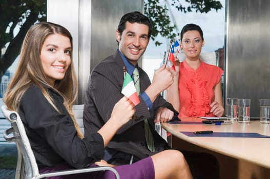 Business executives holding flags in a conference room