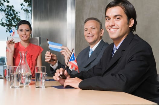 Business executives holding flags in a conference room