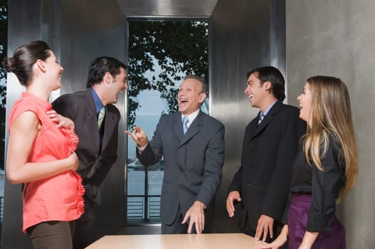 Business executives laughing in a conference room
