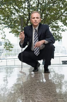 Businessman holding a golf club in an office
