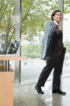 Businessman holding a coat in an office