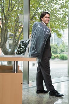 Businessman holding a coat in an office