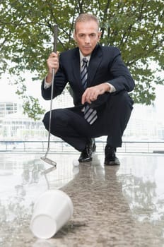 Businessman holding a golf club in an office