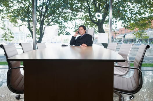 Businessman talking on a mobile phone in a conference room