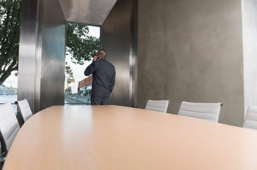 Businessman talking on a mobile phone in a board room