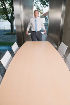 Businessman showing empty pockets in a board room
